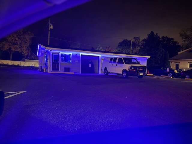 Xclusive Auto Salon shop in Glastonbury, lit up at night